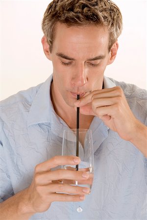 Close-up of a mid adult man drinking with a straw Stock Photo - Premium Royalty-Free, Code: 625-00850769