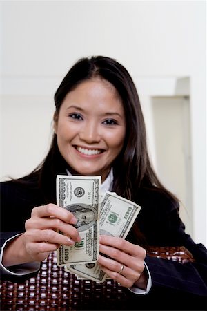 Portrait of a businesswoman holding one hundred dollar bills Stock Photo - Premium Royalty-Free, Code: 625-00850786