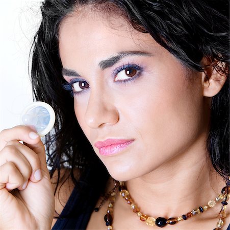 Portrait d'une jeune femme tenant un préservatif Photographie de stock - Premium Libres de Droits, Code: 625-00850815