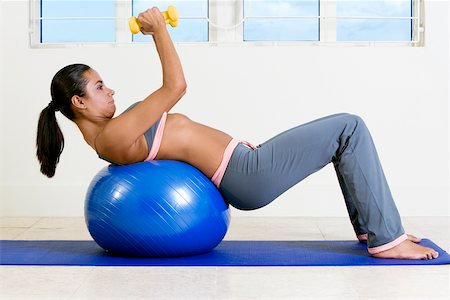 simsearch:625-00901737,k - Side profile of a young woman exercising with dumbbells on a fitness ball Stock Photo - Premium Royalty-Free, Code: 625-00850965