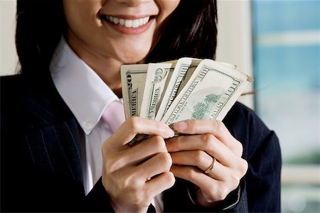 Close-up of a businesswoman holding American dollar bills Fotografie stock - Premium Royalty-Free, Codice: 625-00851003