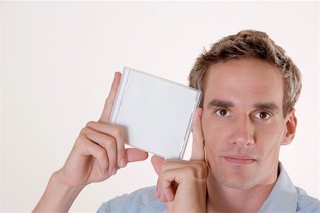 Portrait of a mid adult man holding a CD case Stock Photo - Premium Royalty-Free, Code: 625-00851060