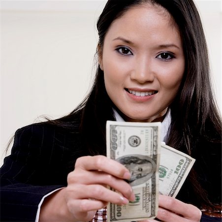 simsearch:625-01095402,k - Portrait of a businesswoman holding one hundred dollar bills Foto de stock - Sin royalties Premium, Código: 625-00851121