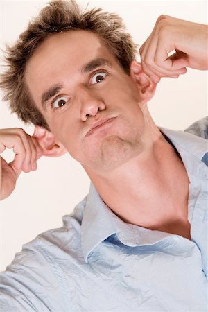 pull funny - Close-up of a young man pulling his ears Stock Photo - Premium Royalty-Free, Code: 625-00851132