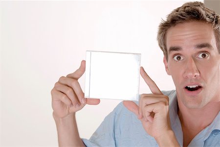 Portrait of a mid adult man holding a CD case Stock Photo - Premium Royalty-Free, Code: 625-00851250