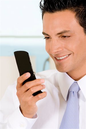 simsearch:625-02266709,k - Close-up of a businessman looking at a mobile phone Foto de stock - Sin royalties Premium, Código: 625-00851367
