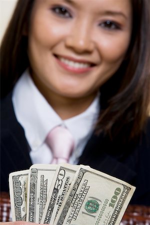 Portrait of a businesswoman holding one hundred dollar bills Fotografie stock - Premium Royalty-Free, Codice: 625-00851397