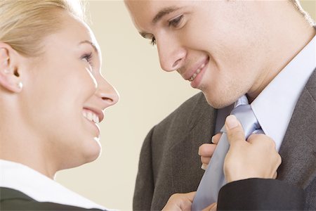 Side profile of a businesswoman adjusting a businessman's tie Stock Photo - Premium Royalty-Free, Code: 625-00851409