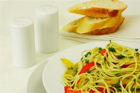 pane all'aglio - Close-up of a plate of noodles near a salt and pepper shaker Fotografie stock - Premium Royalty-Free, Codice: 625-00898695