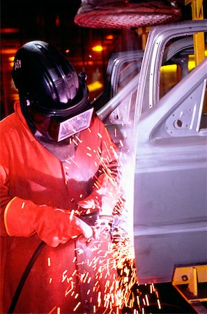 Automobile factory mechanic working on chassis in a shower of sparks Foto de stock - Sin royalties Premium, Código: 625-00899088