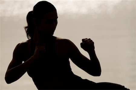 silhouette female martial arts - Silhouette of a young woman exercising Stock Photo - Premium Royalty-Free, Code: 625-00899105