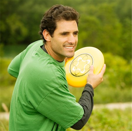 Close-up of a mid adult man throwing a plastic disc Stock Photo - Premium Royalty-Free, Code: 625-00899157