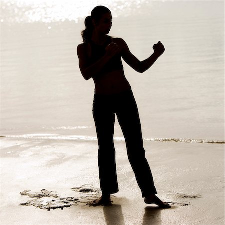 silhouette female martial arts - Silhouette of a young woman practicing martial arts on the beach Stock Photo - Premium Royalty-Free, Code: 625-00899150