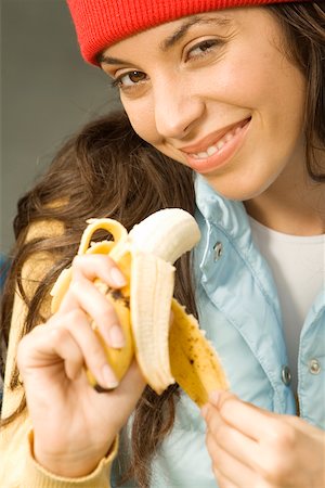 Portrait of a young woman holding a banana Stock Photo - Premium Royalty-Free, Code: 625-00899293