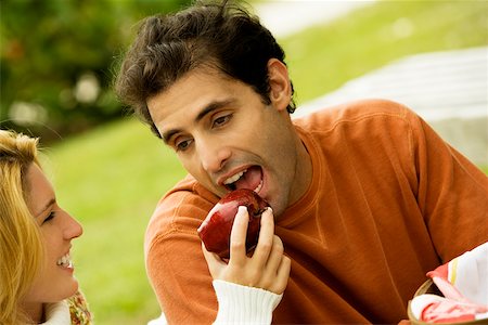flirt women open mouth - Close-up of a young woman feeding an apple to a mid adult man Stock Photo - Premium Royalty-Free, Code: 625-00899410