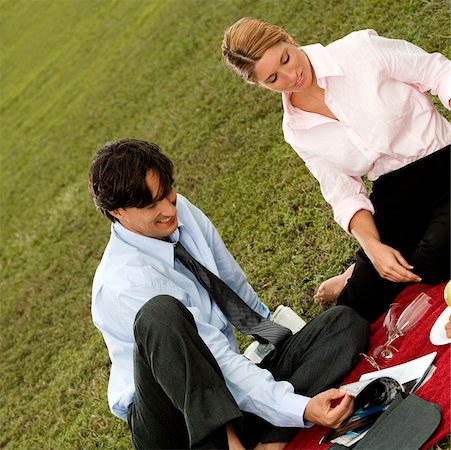High angle view of a businessman and a businesswoman sitting together in the park Stock Photo - Premium Royalty-Free, Code: 625-00899420