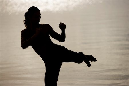 silhouette female martial arts - Silhouette of a young woman practicing martial arts on the beach Stock Photo - Premium Royalty-Free, Code: 625-00899522