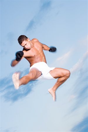 simsearch:625-02266411,k - Low angle view of a young man kicking in mid-air Foto de stock - Sin royalties Premium, Código: 625-00899547