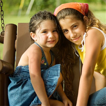 Portrait of two sisters sitting on a swing Stock Photo - Premium Royalty-Free, Code: 625-00899629