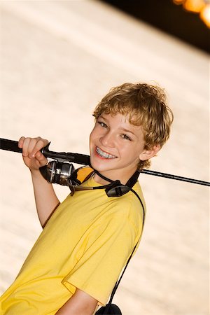simsearch:640-02764425,k - Portrait of a boy smiling carrying a fishing rod Stock Photo - Premium Royalty-Free, Code: 625-00899663