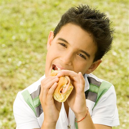 Portrait of a boy eating a burger Foto de stock - Sin royalties Premium, Código: 625-00899686
