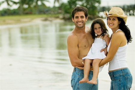 simsearch:625-02266718,k - Portrait of parents carrying their daughter on the beach Fotografie stock - Premium Royalty-Free, Codice: 625-00899695