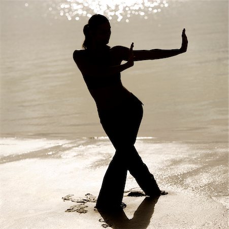 silhouette female martial arts - Silhouette of a young woman practicing martial arts on the beach Stock Photo - Premium Royalty-Free, Code: 625-00899691