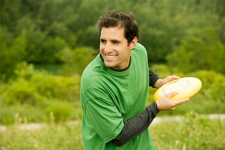 Close-up of a mid adult man throwing a plastic disc Stock Photo - Premium Royalty-Free, Code: 625-00899713