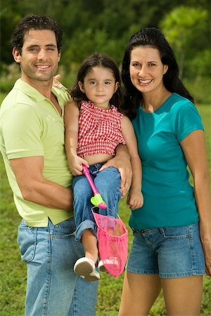 simsearch:625-02266718,k - Portrait of parents and their daughter smiling Fotografie stock - Premium Royalty-Free, Codice: 625-00899737