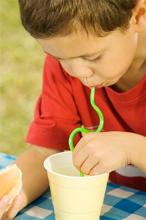 Close-up of a boy drinking with a drinking straw Stock Photo - Premium Royalty-Free, Code: 625-00899752