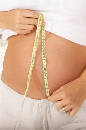 simsearch:859-03600068,k - Mid section view of a pregnant woman measuring her abdomen with a measuring tape Fotografie stock - Premium Royalty-Free, Codice: 625-00899803
