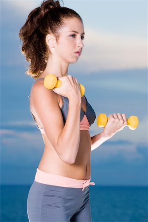 simsearch:625-00901737,k - Side profile of a young woman exercising with dumbbells Stock Photo - Premium Royalty-Free, Code: 625-00899906