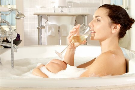 Profil de côté d'une jeune femme tenant un verre de vin dans une baignoire Photographie de stock - Premium Libres de Droits, Code: 625-00899928