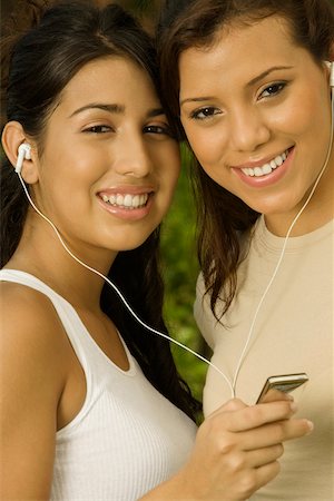 simsearch:625-00899613,k - Portrait of two teenage girls holding an MP3 player listening to music Foto de stock - Royalty Free Premium, Número: 625-00899976