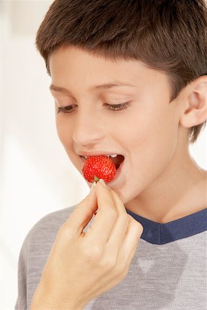 preteens fingering - Close-up of a woman's hand feeding a boy a strawberry Stock Photo - Premium Royalty-Free, Code: 625-00900040
