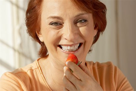 simsearch:625-00838036,k - Portrait d'une femme senior tenant une fraise Photographie de stock - Premium Libres de Droits, Code: 625-00900131