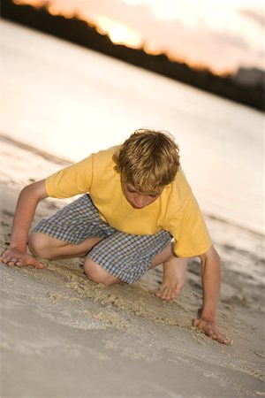 Close-up of a teenage boy playing in sand Stock Photo - Premium Royalty-Free, Code: 625-00900176
