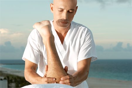 Close-up of a mature man massaging a person's leg Stock Photo - Premium Royalty-Free, Code: 625-00900265