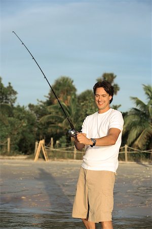 Mid adult man holding a fishing rod Stock Photo - Premium Royalty-Free, Code: 625-00900346