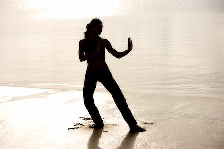 silhouette female martial arts - Silhouette of a young woman practicing martial arts on the beach Stock Photo - Premium Royalty-Free, Code: 625-00900381