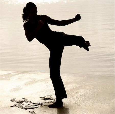 silhouette female martial arts - Silhouette of a young woman practicing martial arts on the beach Stock Photo - Premium Royalty-Free, Code: 625-00900530