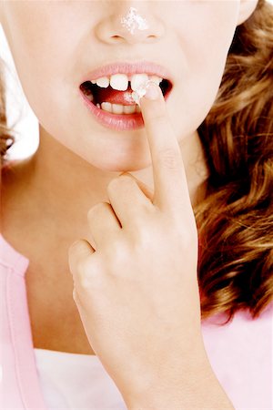 Gros plan d'une jeune fille tenant un morceau de sucre entre ses dents Photographie de stock - Premium Libres de Droits, Code: 625-00900546