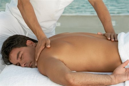 Close-up of a massage therapist massaging a mid adult man's back Stock Photo - Premium Royalty-Free, Code: 625-00900547