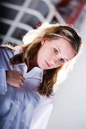 Close-up of a young woman buttoning her shirt Fotografie stock - Premium Royalty-Free, Codice: 625-00900677