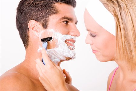 shaving man woman - Close-up of a young woman shaving a mid adult man's face Stock Photo - Premium Royalty-Free, Code: 625-00900960