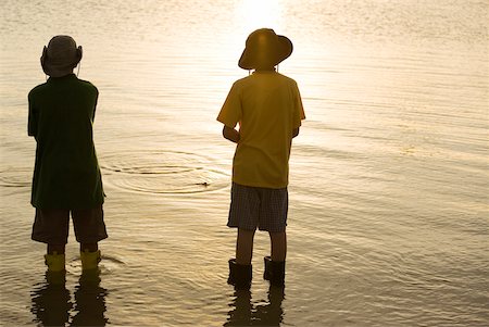 Rear view of two brothers standing in water Stock Photo - Premium Royalty-Free, Code: 625-00901009