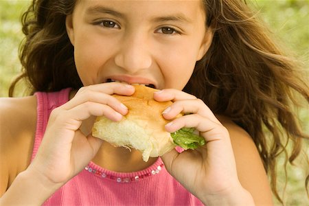 Portrait of a girl eating a burger Stock Photo - Premium Royalty-Free, Code: 625-00901162