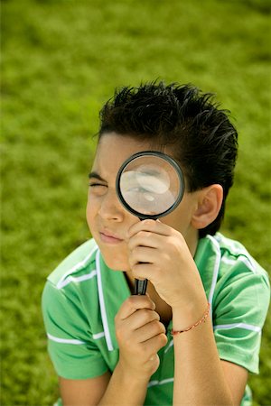 Portrait of a boy looking through a magnifying glass Stock Photo - Premium Royalty-Free, Code: 625-00901226