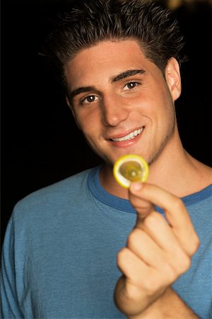 simsearch:625-00851085,k - Portrait of a young man holding a condom Foto de stock - Royalty Free Premium, Número: 625-00901308