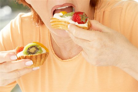 simsearch:625-01096495,k - Mid section view of a senior woman eating a strawberry tart Fotografie stock - Premium Royalty-Free, Codice: 625-00901342